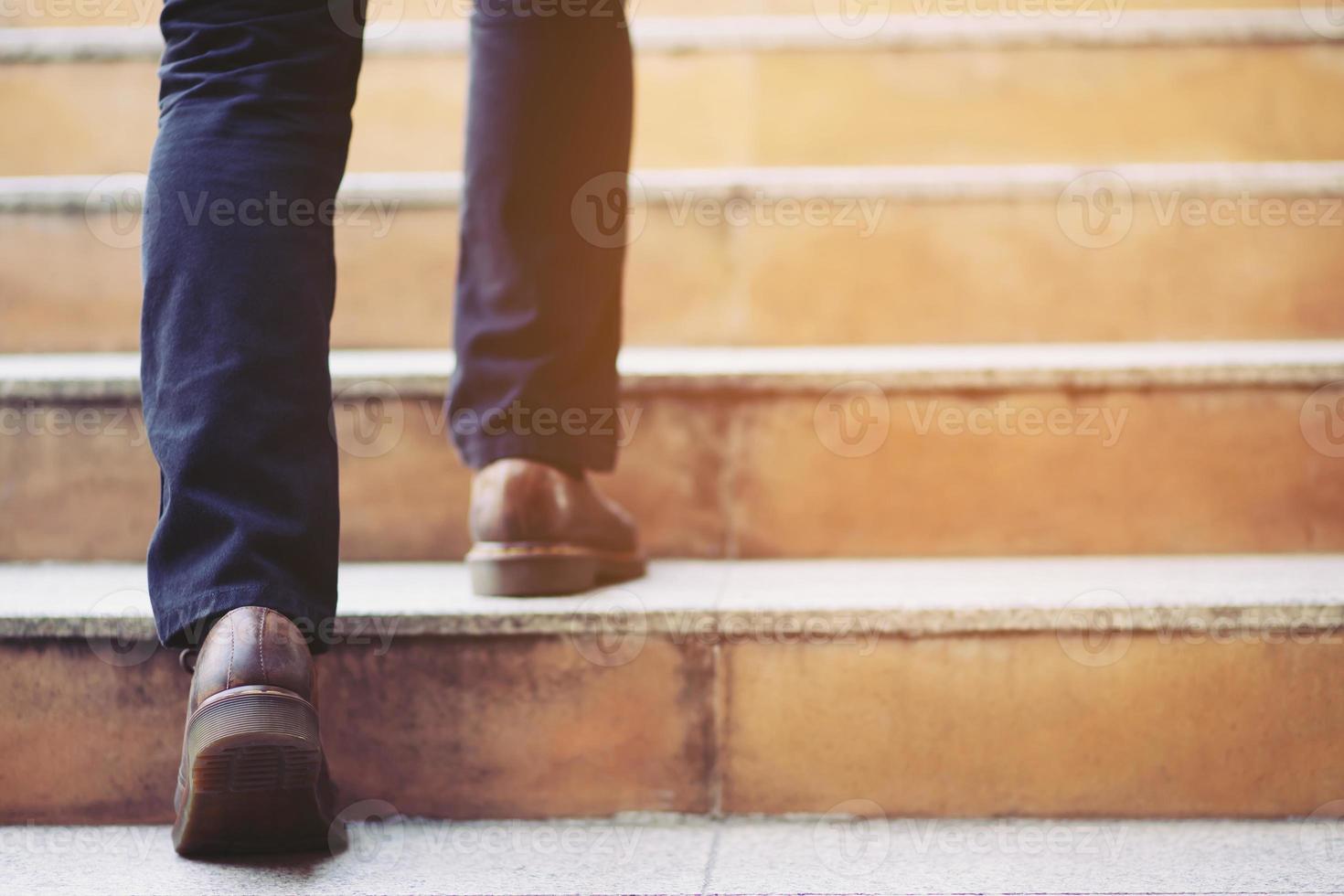 Close up legs shoes of young business man One person walking stepping going up the stairs in modern city, go up, success, grow up. with filter Tones retro vintage warm effect. stairway photo