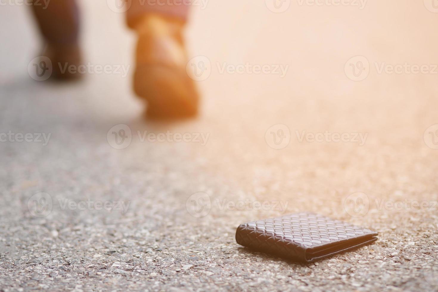 businessman had lost leather wallet with money on the street. Close-up of wallet lying on the sidewalk in during the trip to work. photo