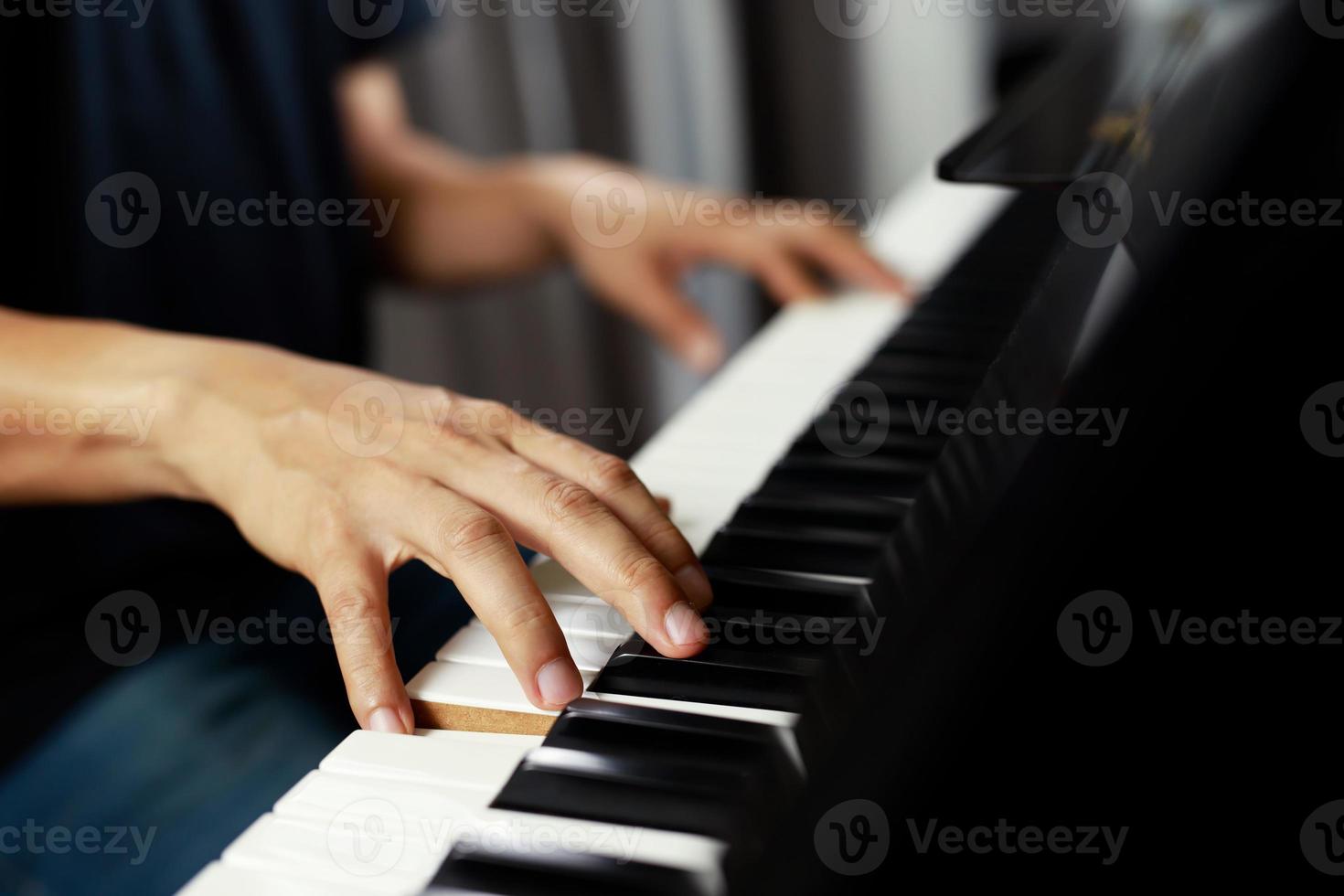 close up of hand people man musician playing piano keyboard with selective focus keys. can be used as a background. photo