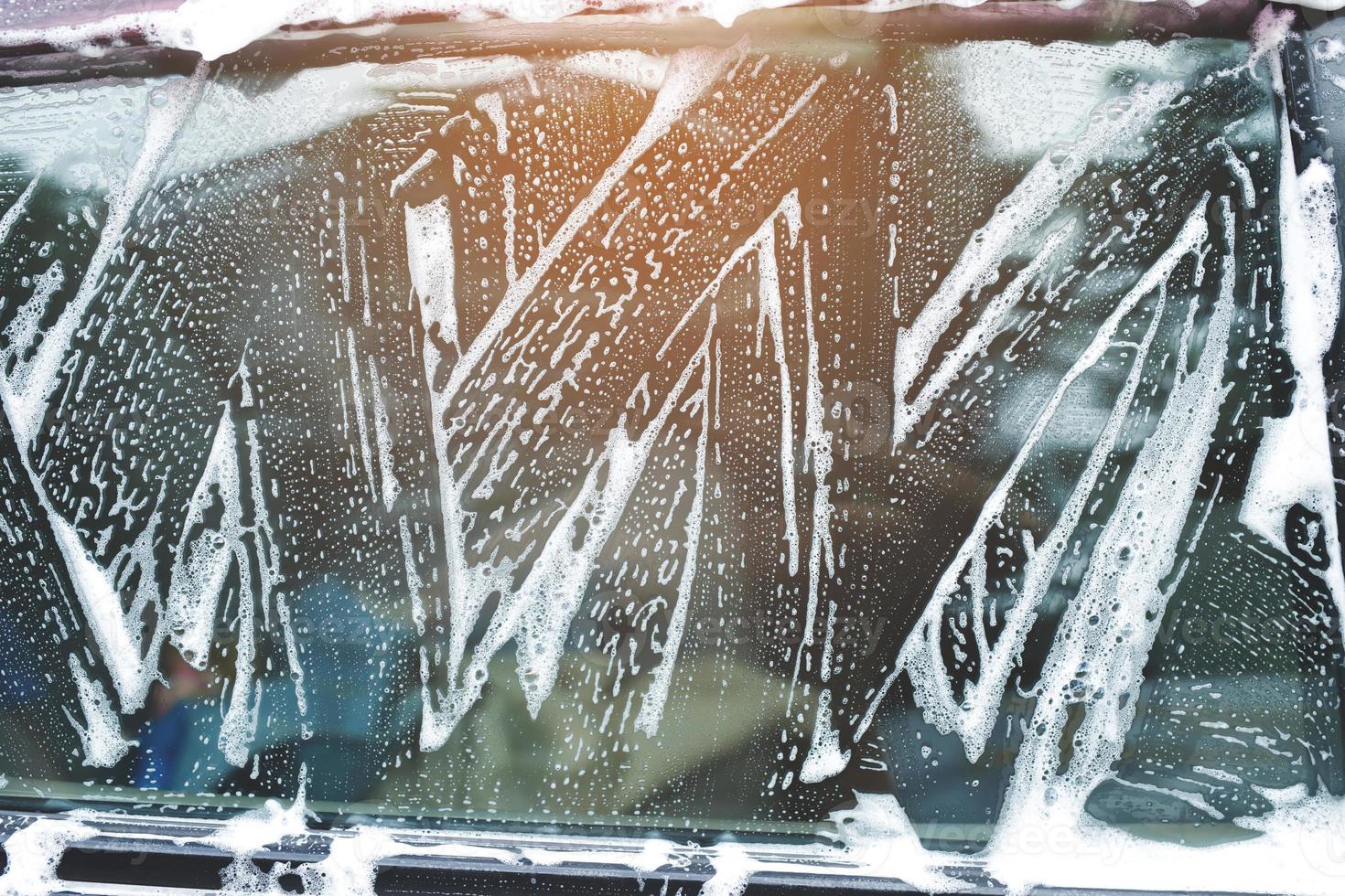 Outdoor car wash foam and soap on black background. abstract pattern , Banner Background Concept. Car Washing and Cleaning Backdrop with Copy Space. photo