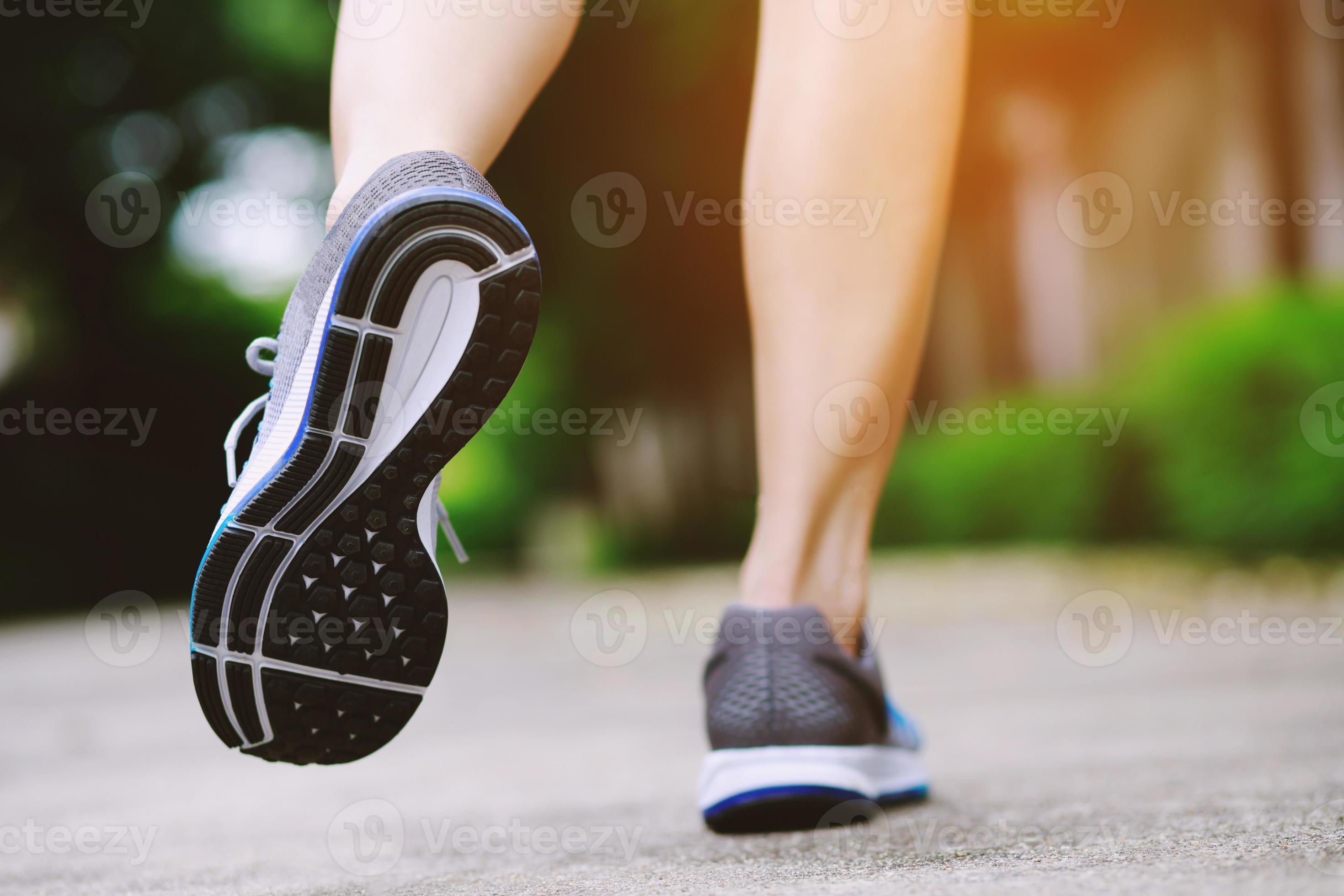 Sportswoman foot runner trail running outdoors. close up on shoe behind