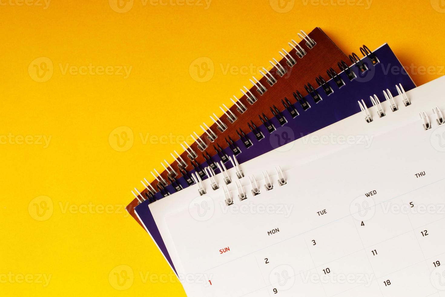 close up top view calendar schedule to make appointment meeting or manage timetable each day lay on yellow background for planning work and travel concept. photo