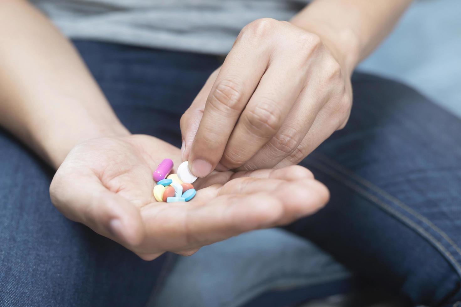 close up hand man holding taking multiple pills. Stop drug use Taking Medication health care medical concept. photo