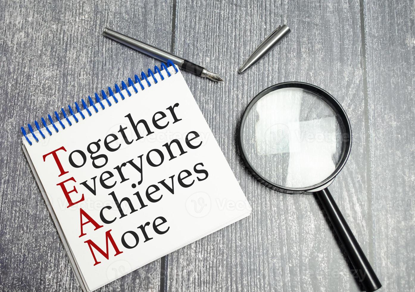 together everyone achieves more words, pen and magnifying glass photo