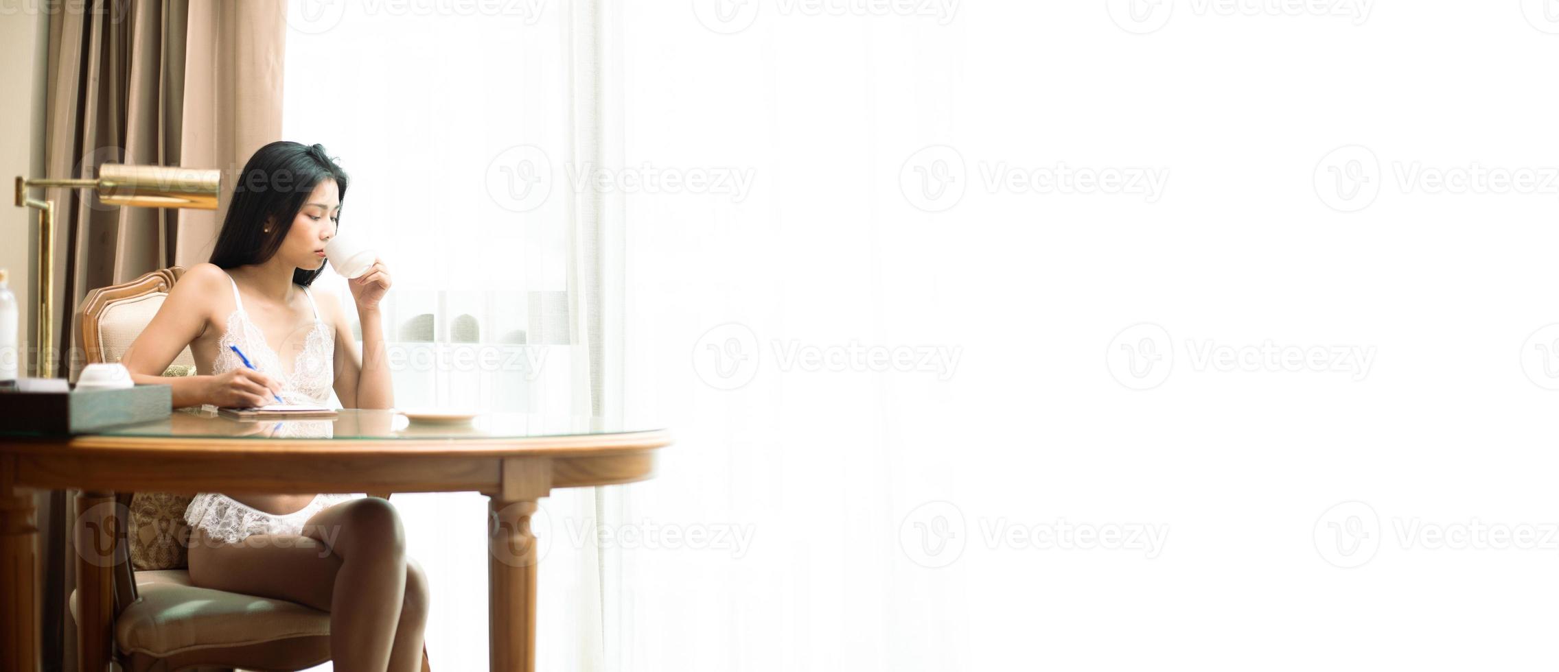 Young 20s Asian Sexy woman working on smart internet phone in lingeries in morning photo