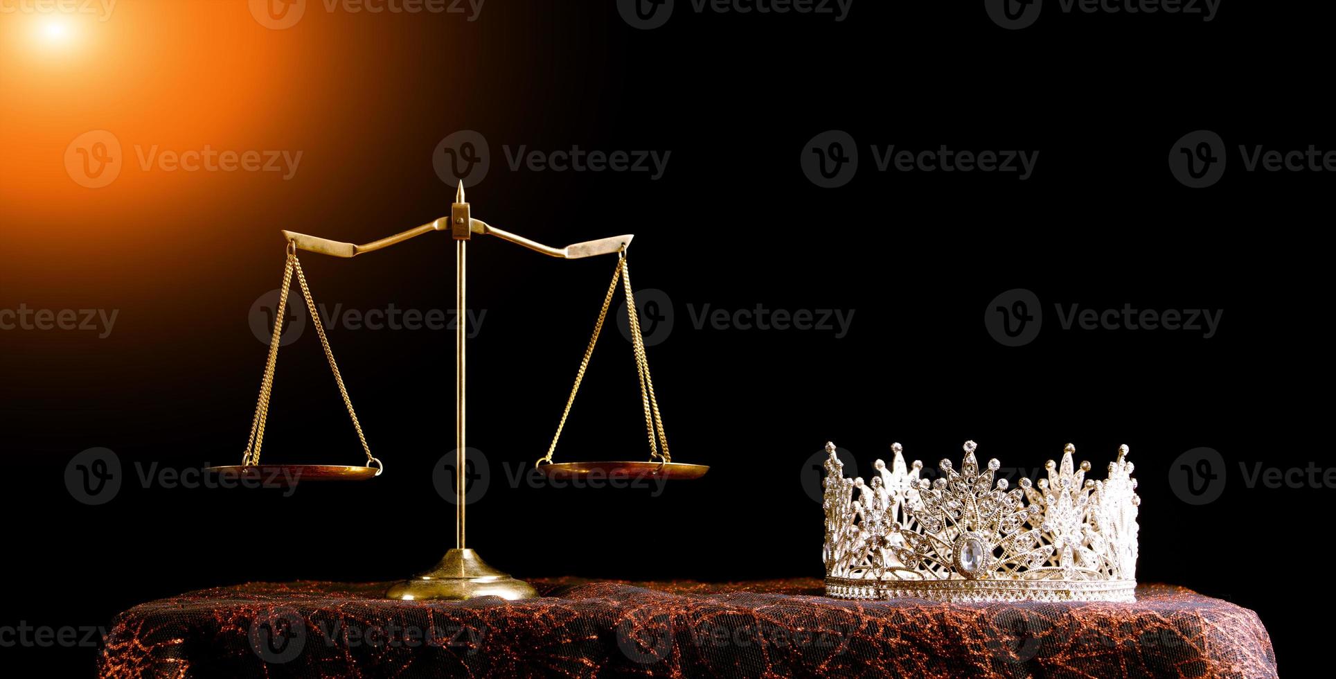 La corona de diamantes del concurso Miss Beauty Queen y el equilibrio de la justicia a escala están en el fondo negro como una fuga de luz en la rampa. concepto de equidad e injusticia en el negocio de concursos de concursos, espacio de copia foto