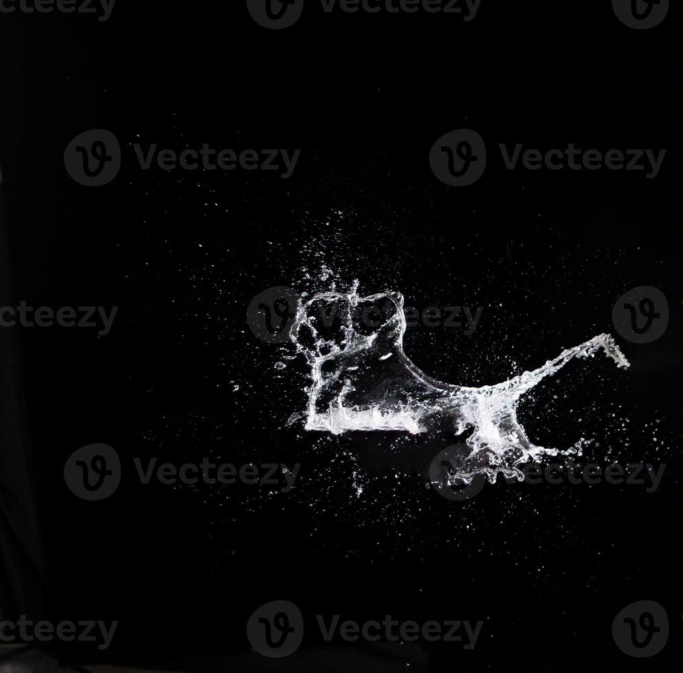 Water splash in air drop over black background, studio lighting high speed photo