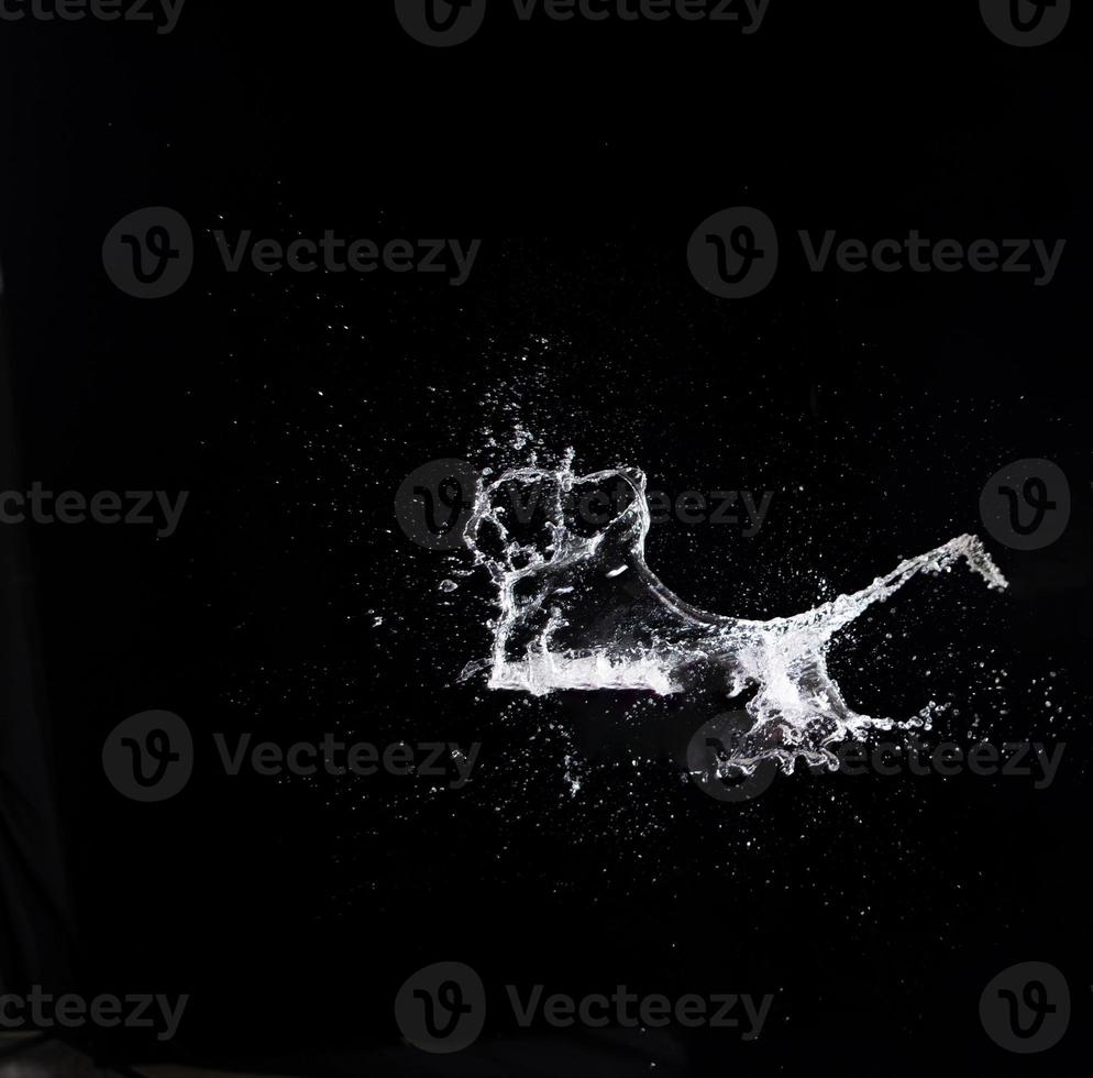 Water splash in air drop over black background, studio lighting high speed photo