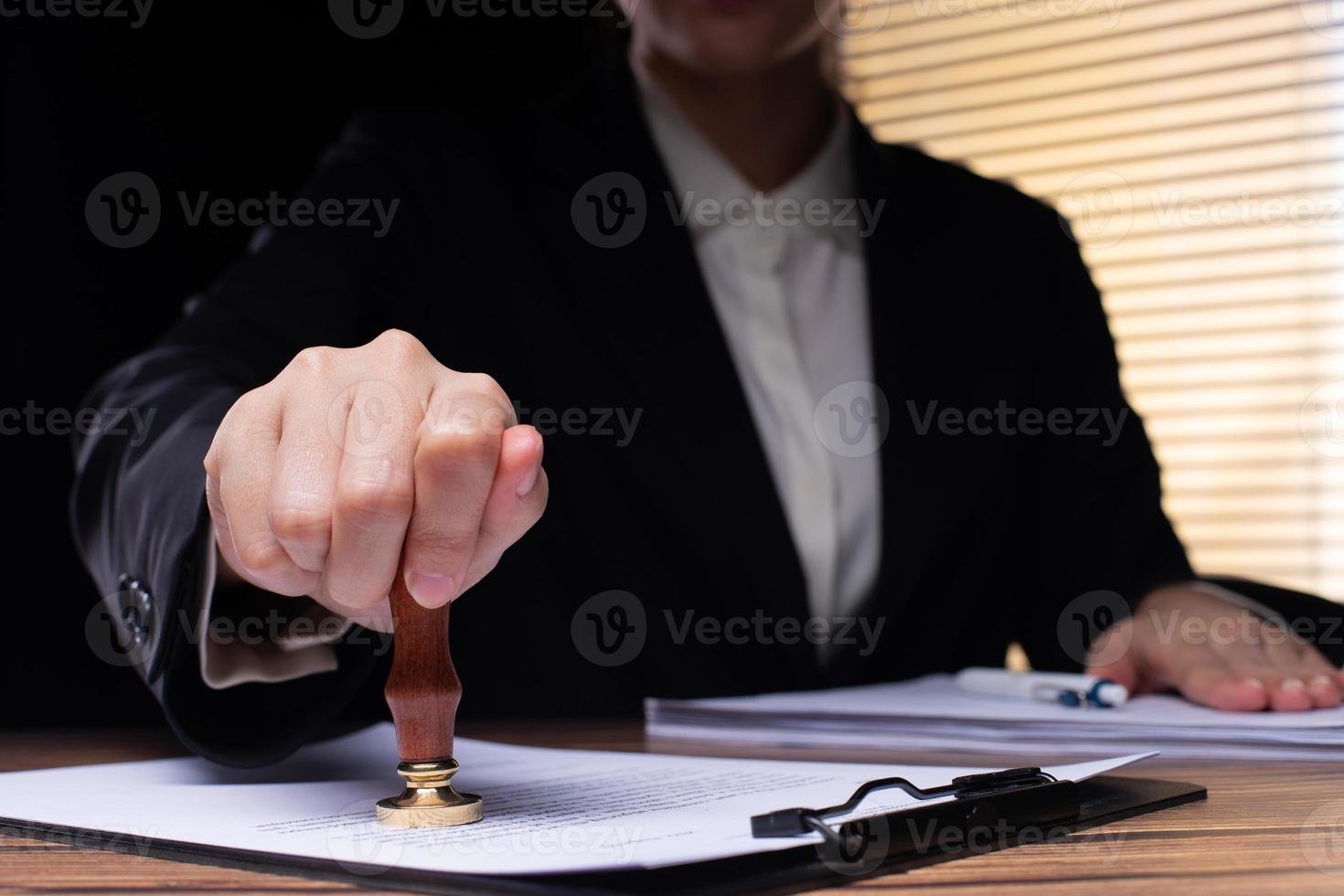 Person Signing Approval document, certificate, legal agreement in office by pen and stamp hand. Authority apply law to do contract paperwork form by public notary clerk or official lawyer, copy space photo