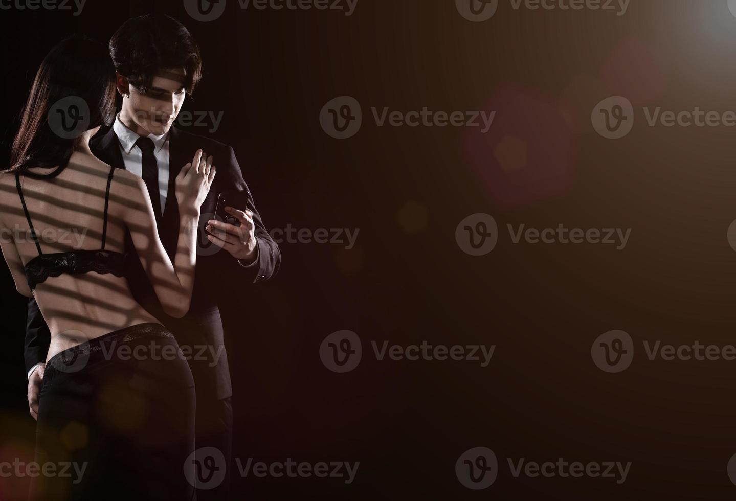 Young Couple embraces with love, business man try to use internet phone, ignore girlfriend photo