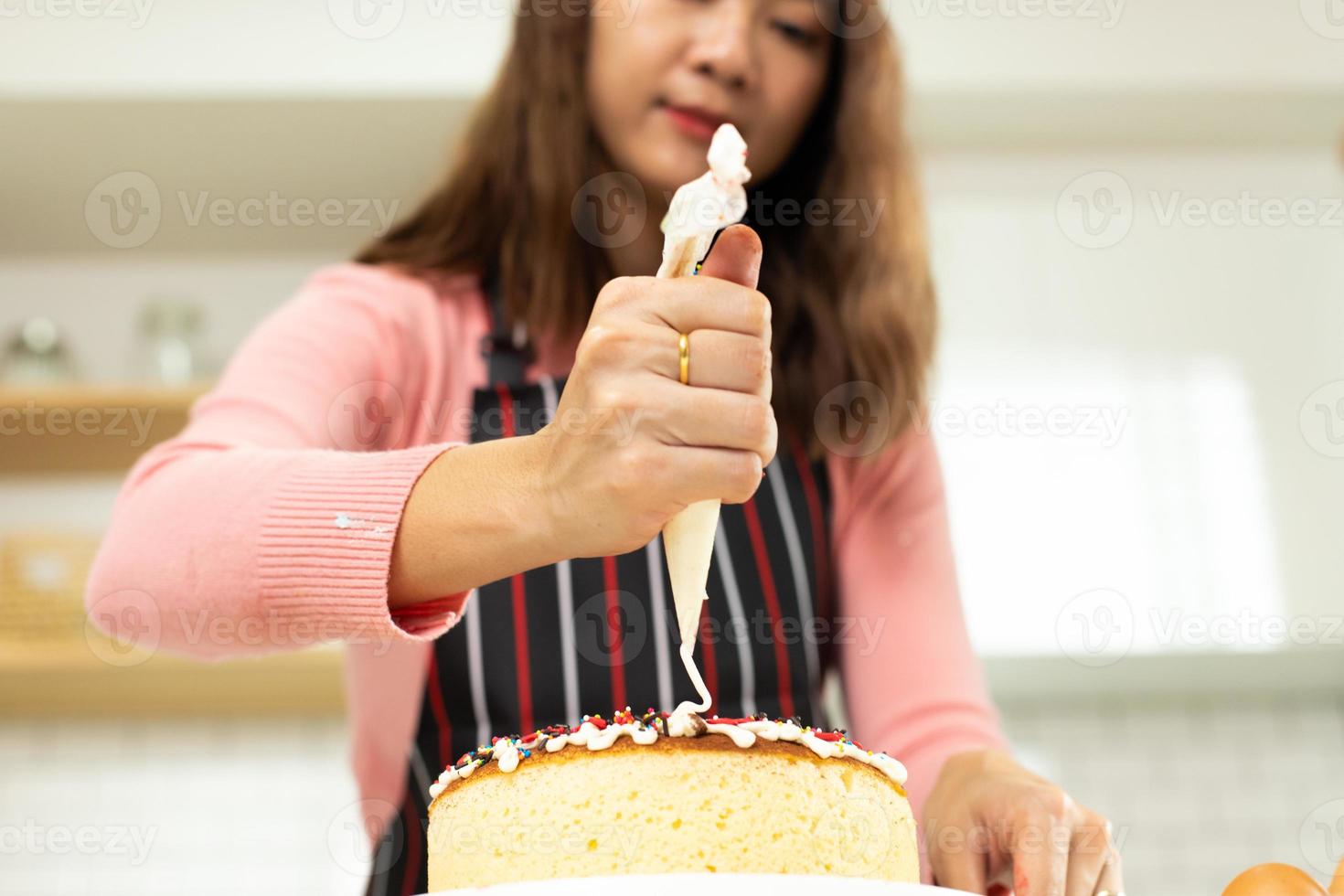 Asian young adult woman learn how to bakery cooking cake online course in kitchen. Female mother video to cyberspace class on laptop as blogger social media content and streaming learning, copy space photo