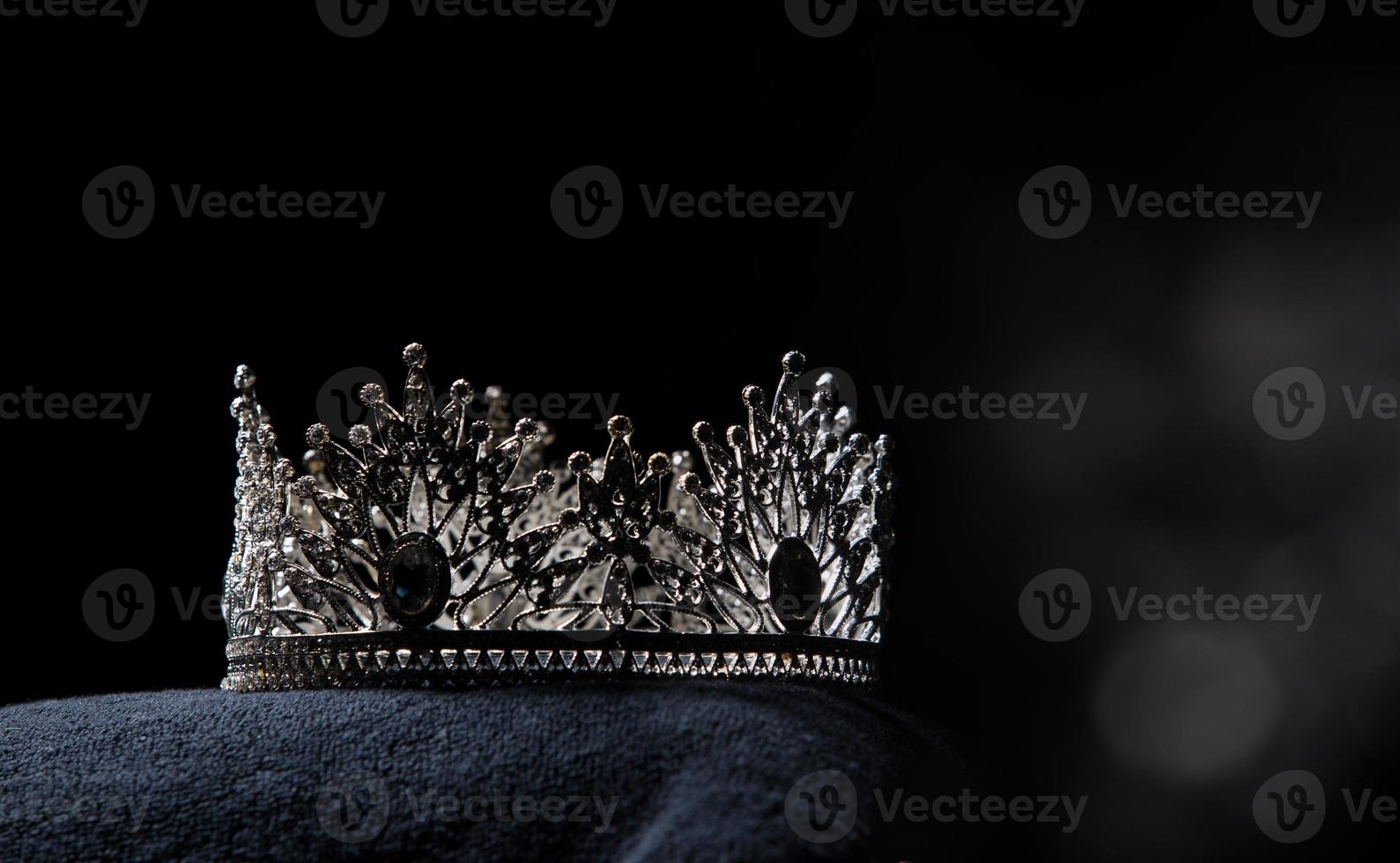 Diamond Silver Crown for Miss Pageant Beauty Contest, Crystal Tiara jewelry decorated gems stone and abstract dark background on black velvet fabric cloth, Macro photography copy space for text logo photo