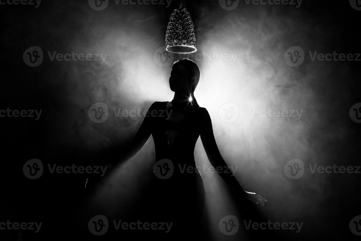 Silhouette abstract of two hands try to reach Diamond Crown as Miss Beauty Queen Pageant Contest as final competition, finale winner moment. Backlit smoke low exposure dark background copy space photo