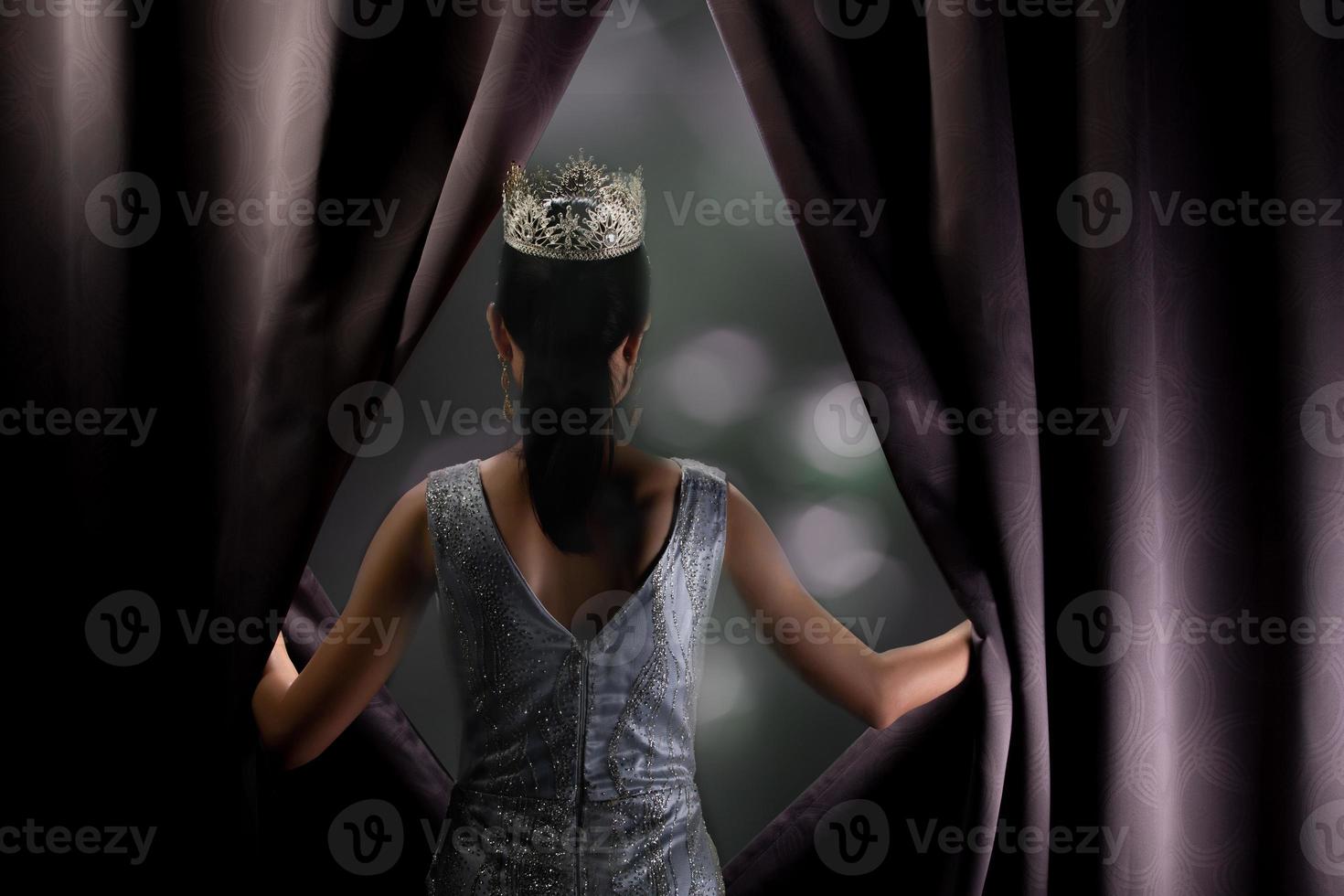 Miss Pageant Beauty Contest wears sequin Evening Gown long dress with sparkle Diamond Crown, Asian Woman opens purple Curtain after win Final round as new way life, opportunity, change everything photo