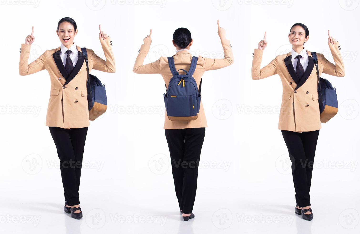 Full length 20s young Mix Race Woman business salesman backpacks, Pointing finger up in Air, wear formal blazer and shoes. Office female stands feels happy smile over white background isolated photo
