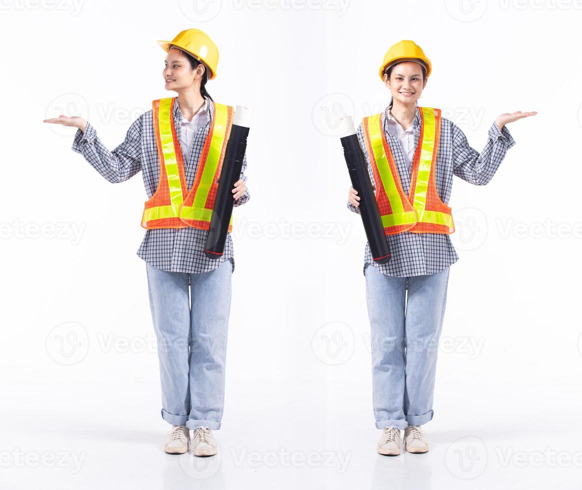 Full length 20s young Mix Race engineer contractor Woman, showing empty palm hand, wear safety vast hardhat blueprint. Office female stands feels smile happy over white background isolated photo