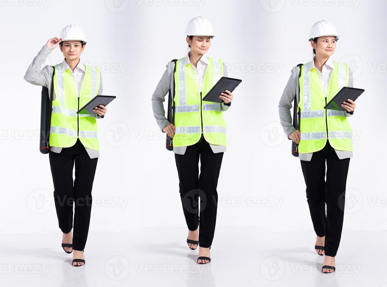 Full length 20s young Mix Race engineer architect client Woman, walking forward left right, wear safety vast hardhat tablet. Office female stands feels smile happy over white background isolated photo