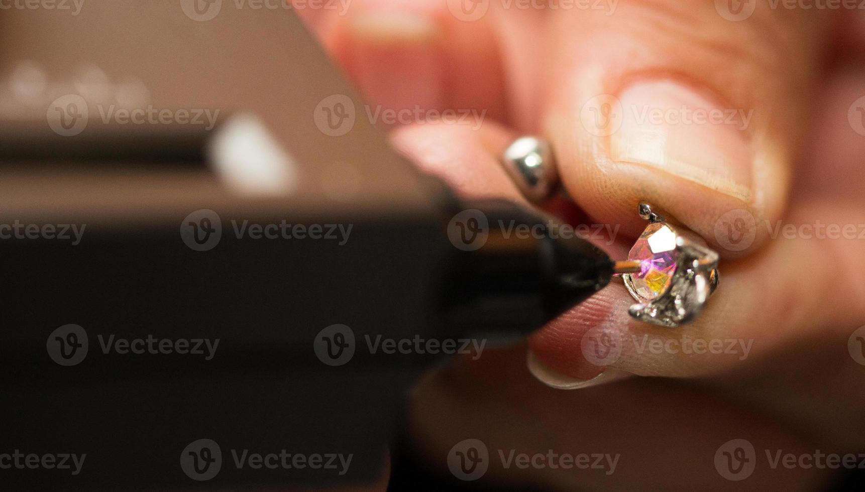 Golden Ring in hands ready to check real or not with Diamond Tester Gemstone Selector Gems LED Indicator Jewelry kits Test, Portable electronic device to peep quick, precise, safe, selective focus photo