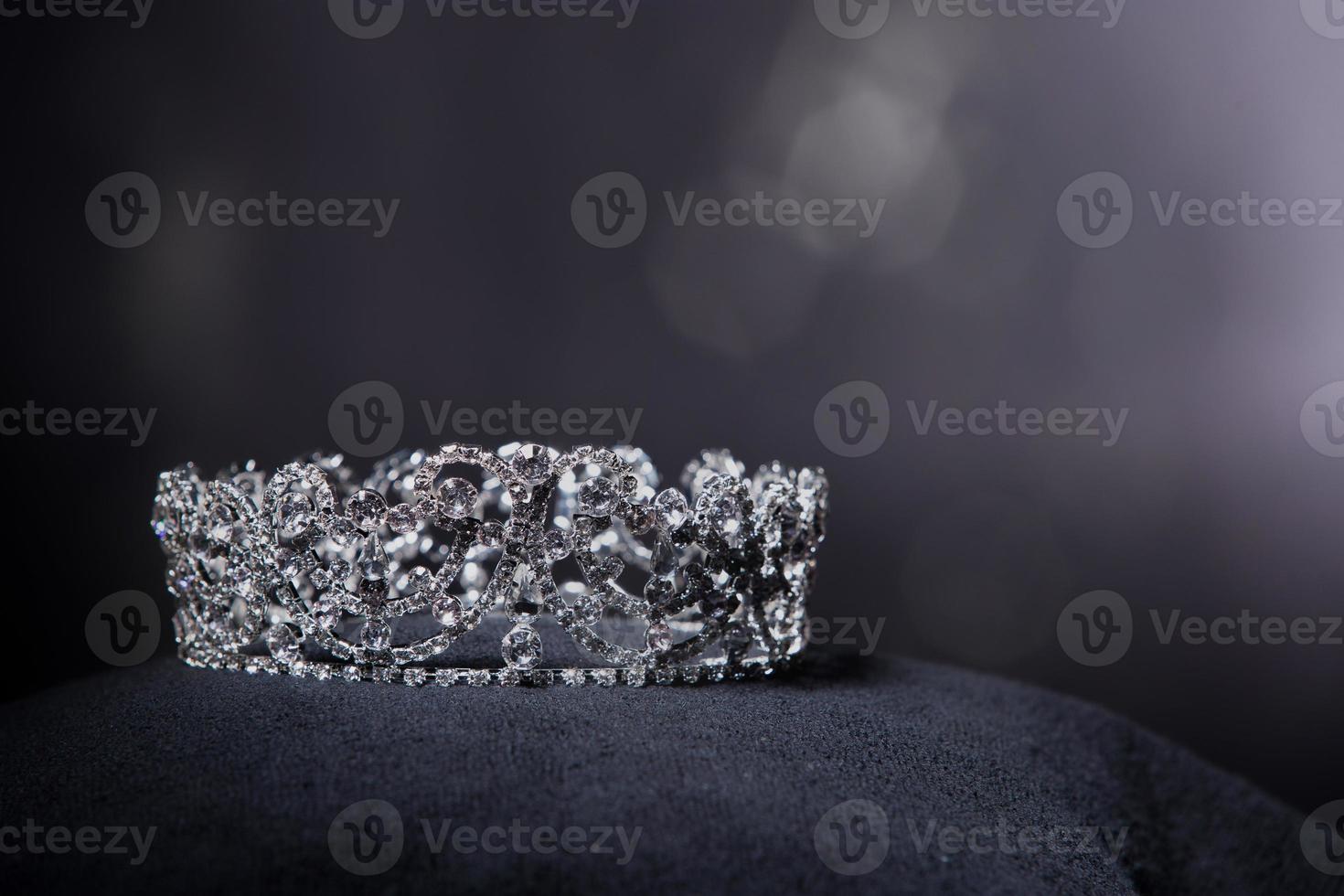 Diamond Silver Crown for Miss Pageant Beauty Contest, Crystal Tiara jewelry decorated gems stone and abstract dark background on black velvet fabric cloth, Macro photography copy space for text logo photo