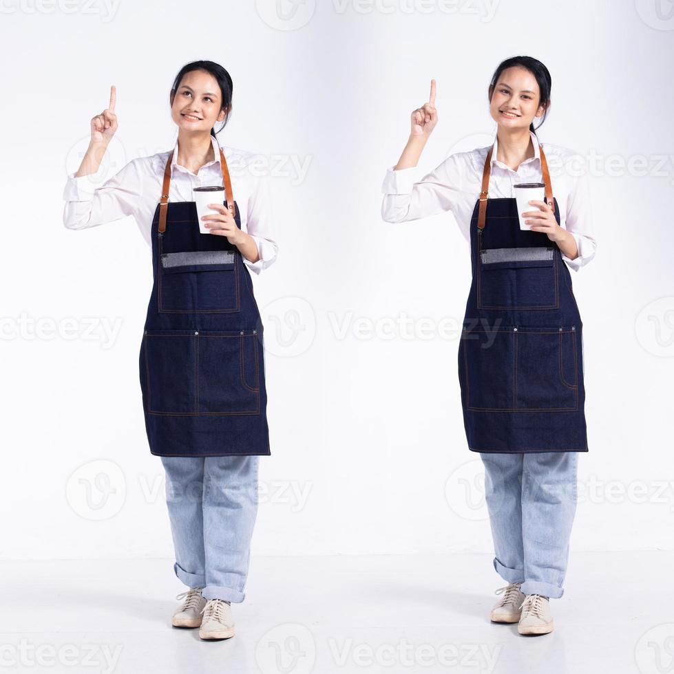 Full length 20s young Mix Race Barista shop restaurant Woman, pointing finger up in Air, wear apron coffee cup. Office female stands feels smile happy over white background isolated photo
