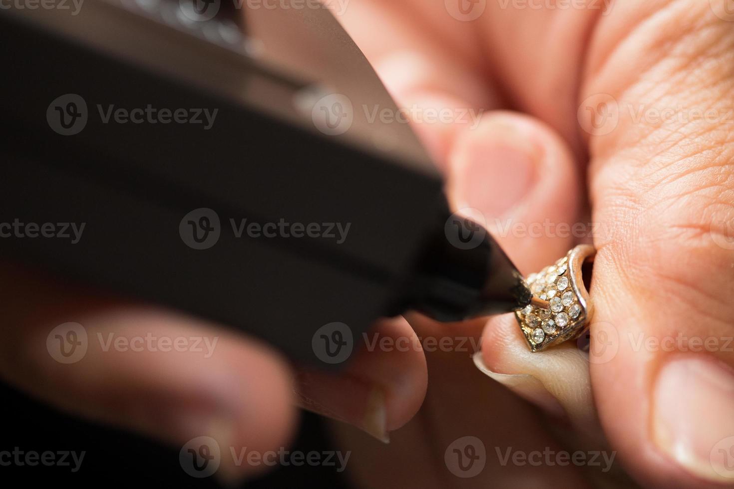 Golden Ring in hands ready to check real or not with Diamond Tester Gemstone Selector Gems LED Indicator Jewelry kits Test, Portable electronic device to peep quick, precise, safe, selective focus photo