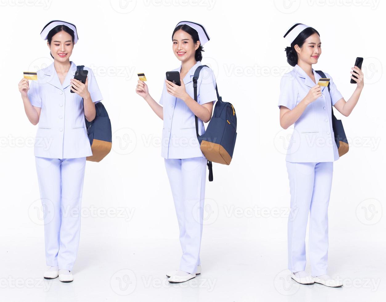 Full length 30s 20s Asian Woman Nurse hospital, shopping online, wear formal uniform pant shoes. Smile Hospital female carry backpack credit card internet phone over white background isolated photo