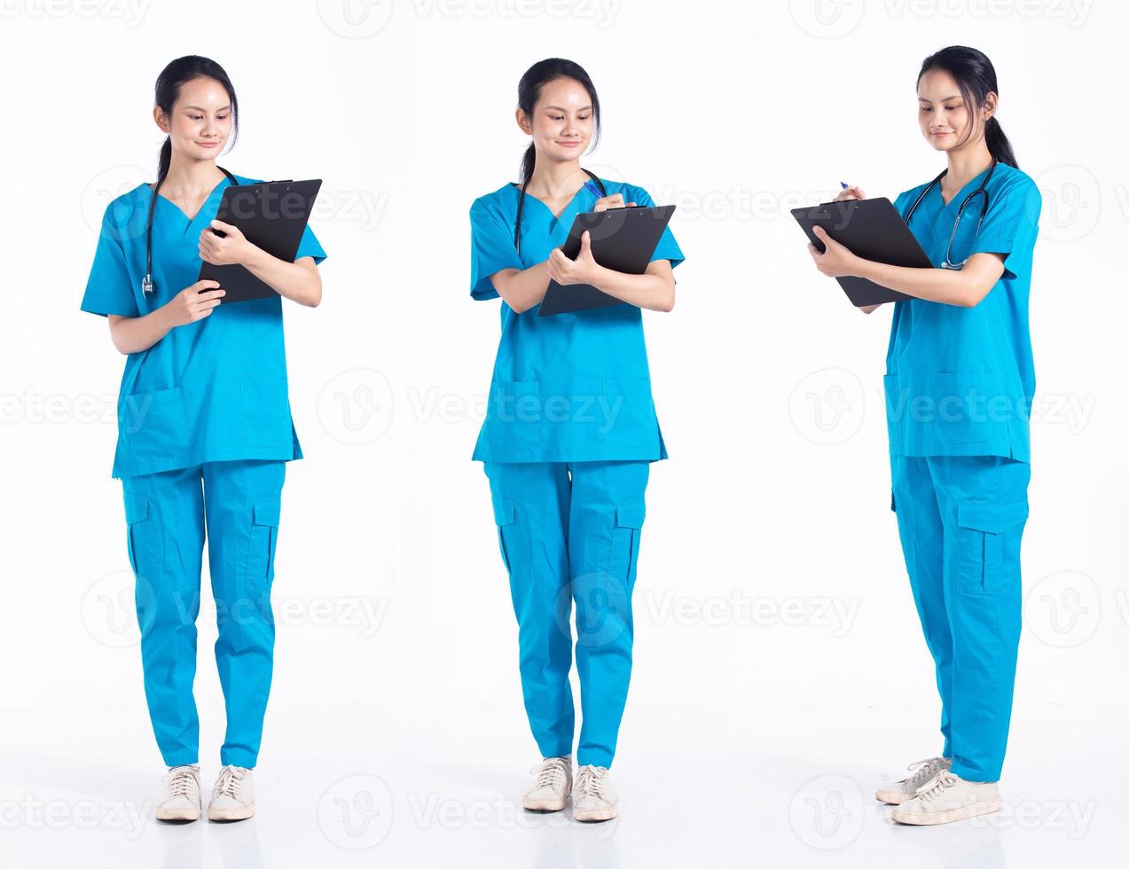 mujer joven de 20 años de duración, enfermera de hospital de raza mixta, trabajando duro en el historial del paciente, use uniforme azul de estetoscopio. la doctora siente estrés sobre un fondo blanco aislado foto