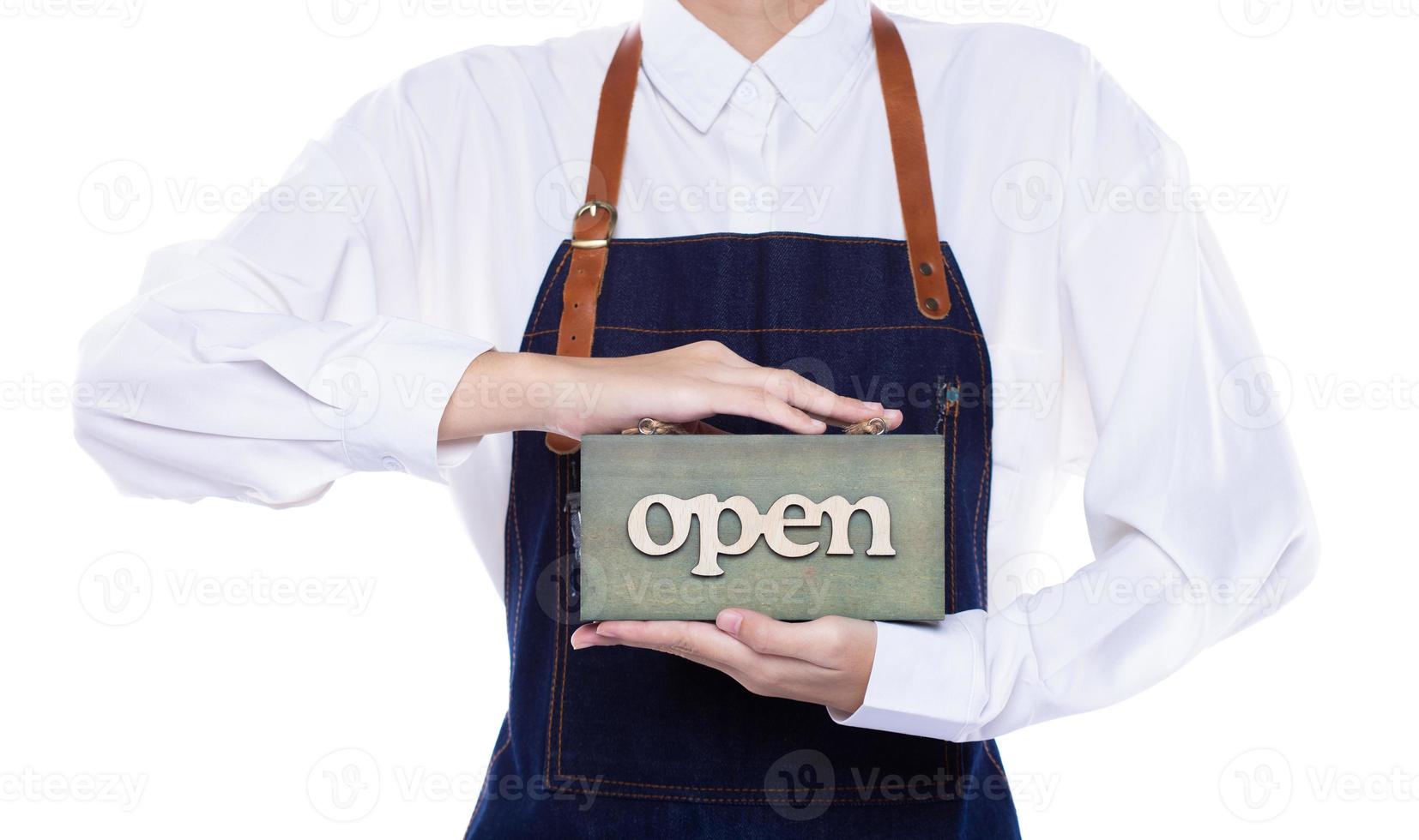 Owner person hold Open Sign Business to show service at door entrance store, cafe, retail and welcome shop. Happy Entrepreneur female wear waitress dress as open business time again concept photo