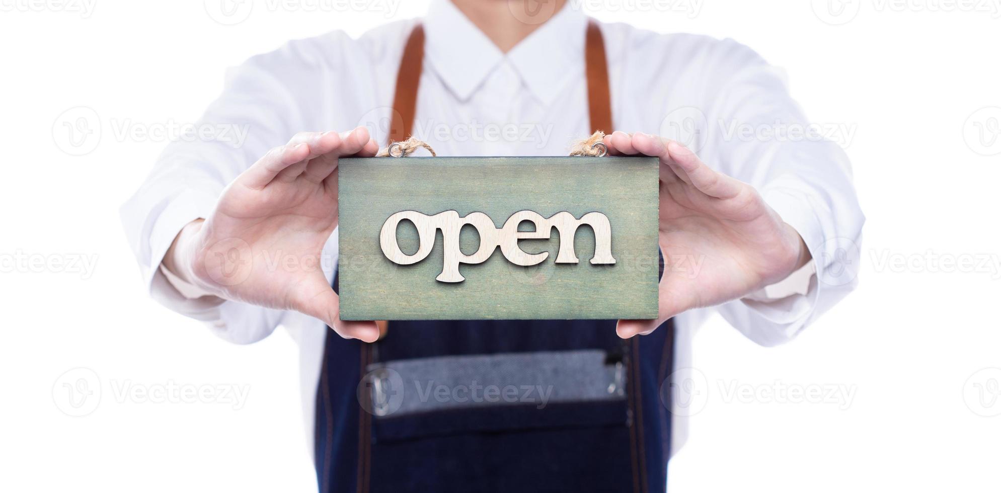 Owner person hold Open Sign Business to show service at door entrance store, cafe, retail and welcome shop. Happy Entrepreneur female wear waitress dress as open business time again concept photo