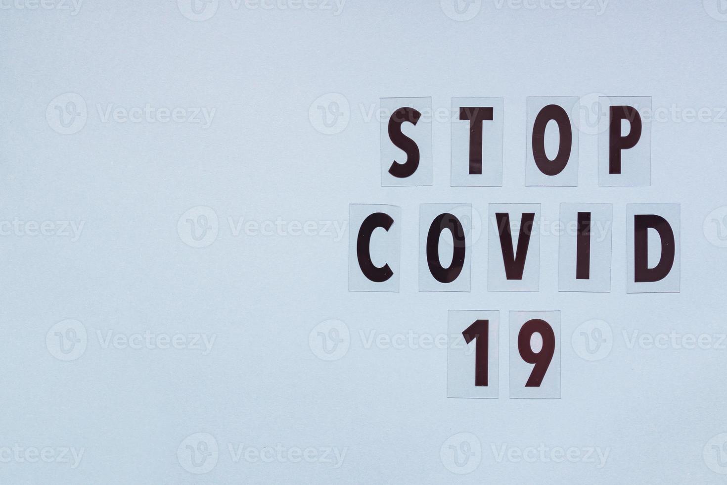 Text stop covid -19 on blue background with copy space. photo