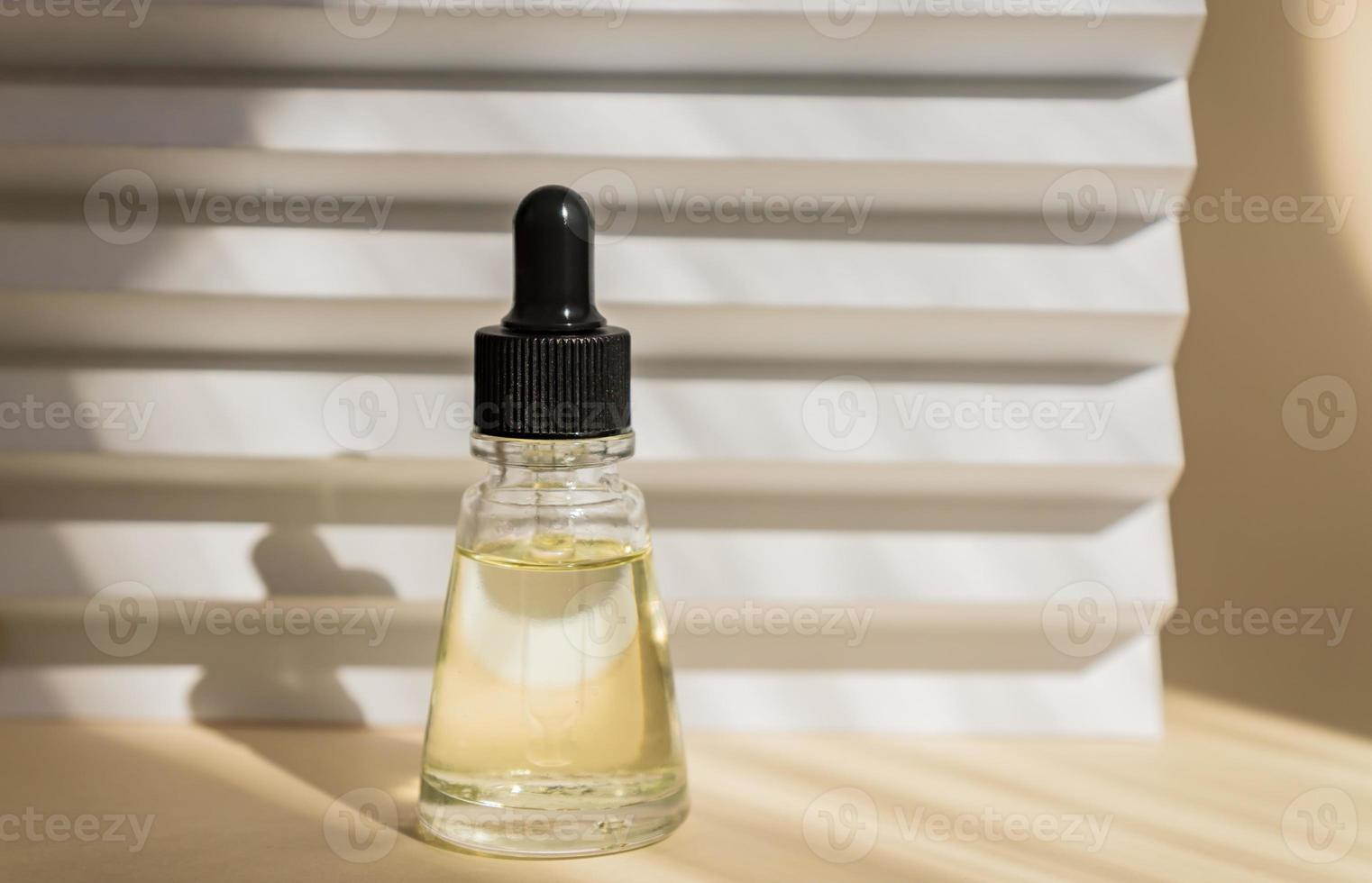 Anti aging serum with collagen and peptides in glass bottle with dropper on white striped background with shadows. Anti-age product, luxury face care photo