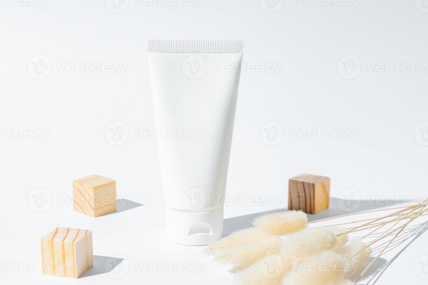 beauty spa medical skincare and cosmetic lotion cream bottle packaging on white background with wooden cubes and dry flowers, healthy and medicine concept photo