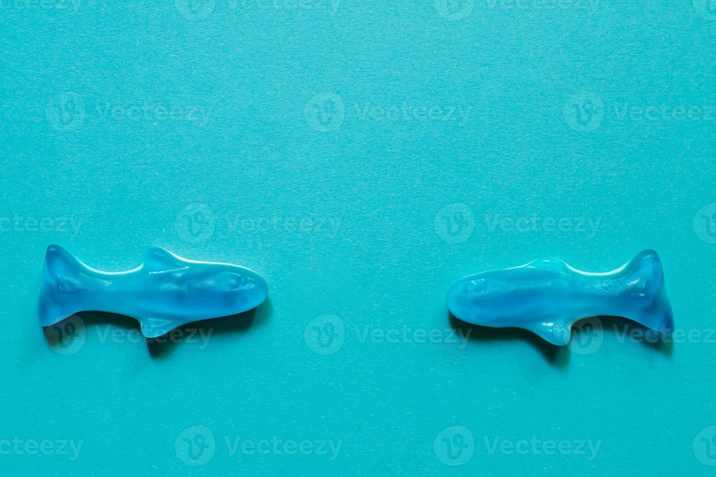blue jelly sweets top view. Delicious marmalade. Candy in the shape of fish on blue background with copy space photo