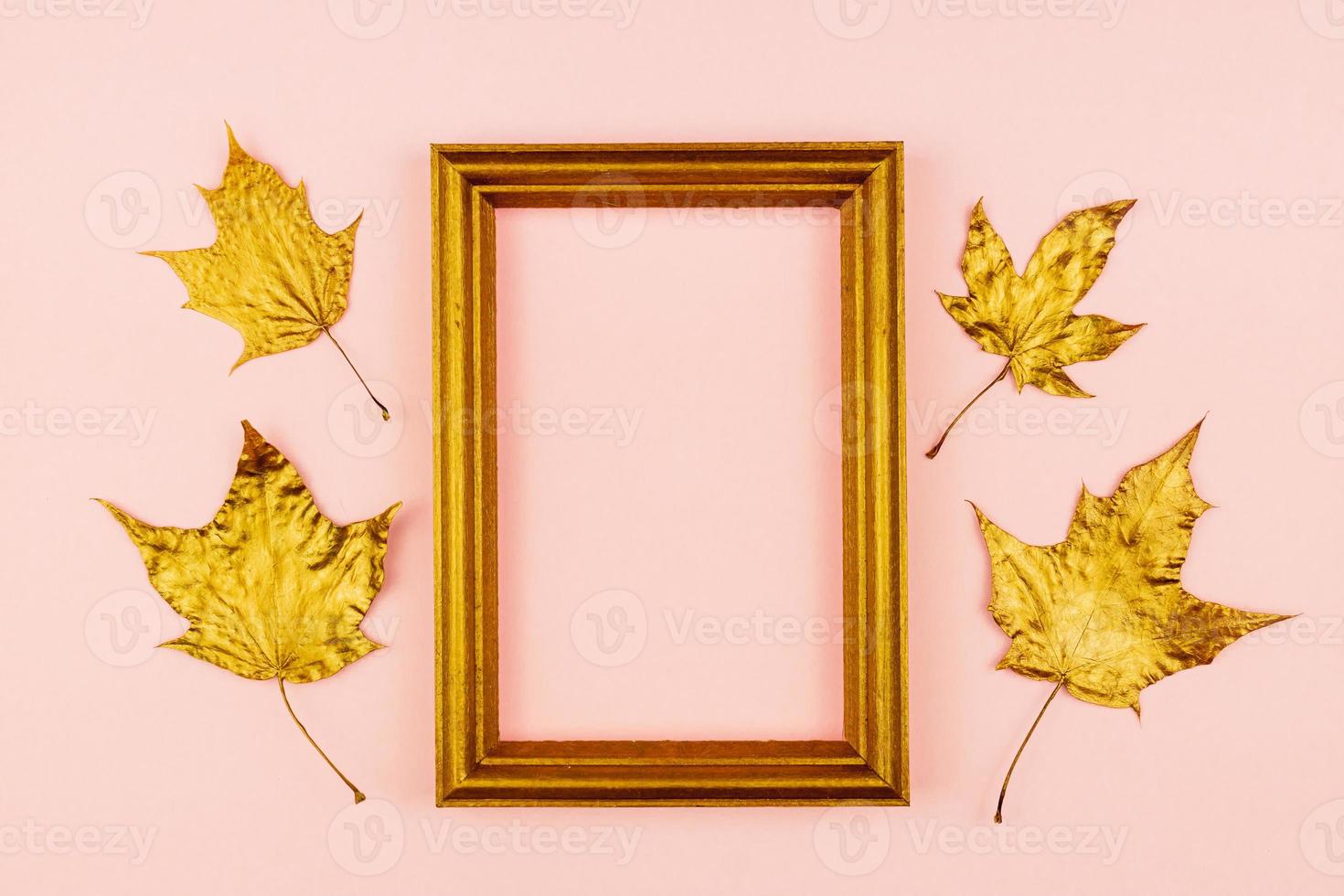 Autumn bouquet of golden painted maple leaves on pink background. Trendy concept. Flay lay in minimalism style. photo
