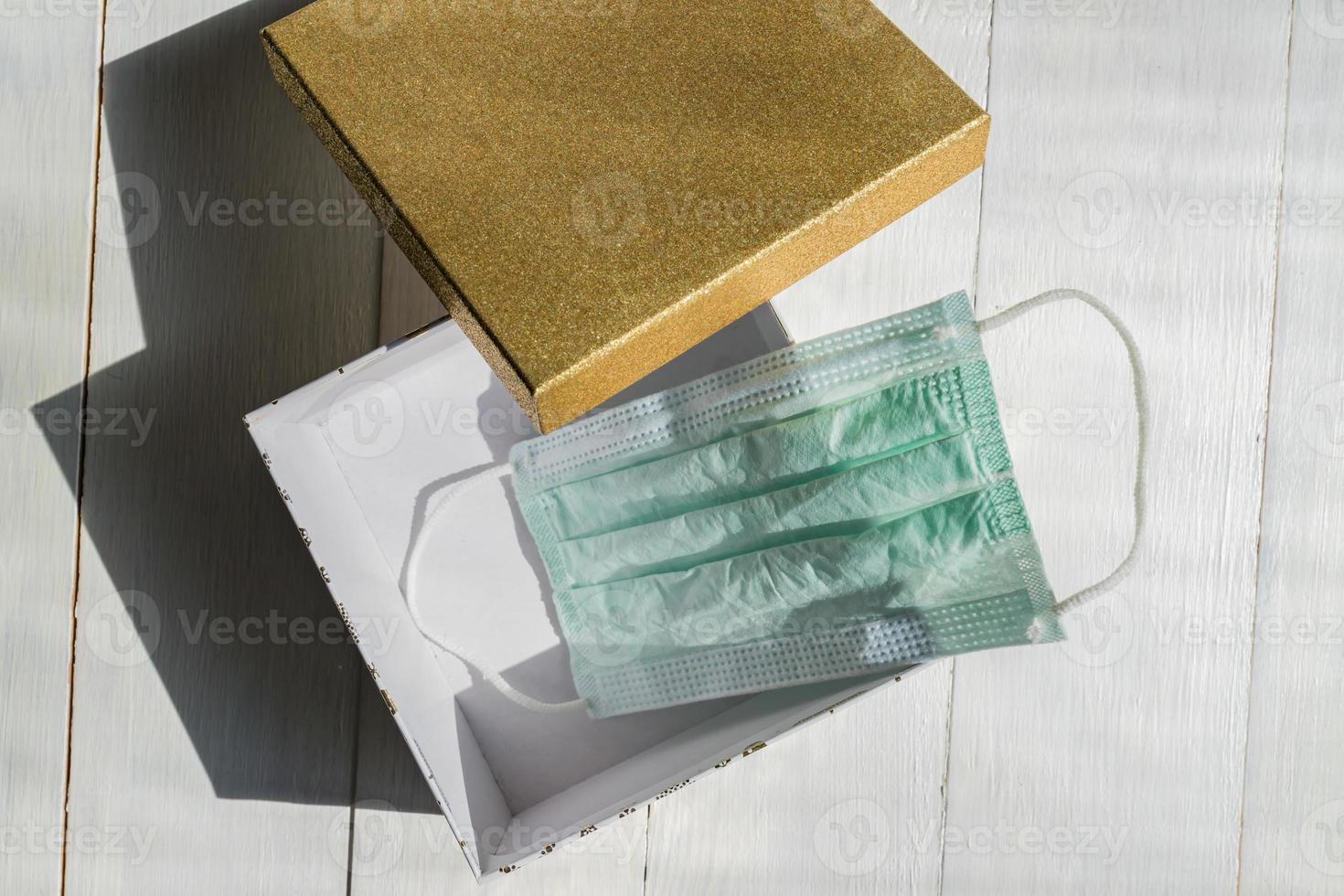 top view of medical mask in gift box on white table. hygienic quarantine concept. Flat lay, top view photo