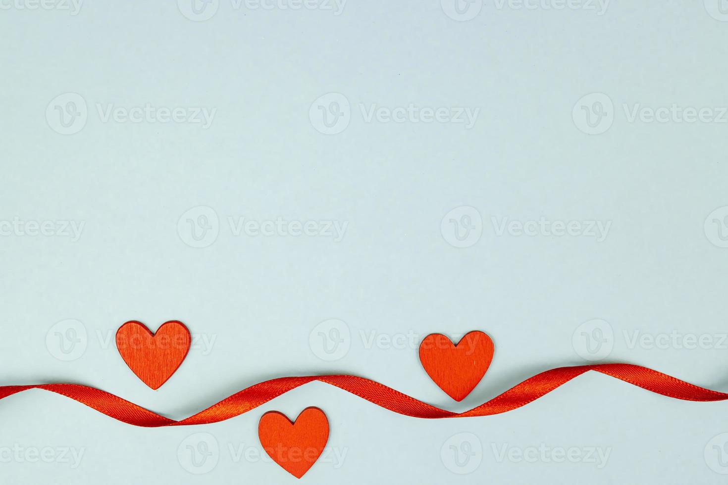 Red sequins heart with satin ribbon on blue background. Creative minimal layout with copy space for St Valentine Day. photo