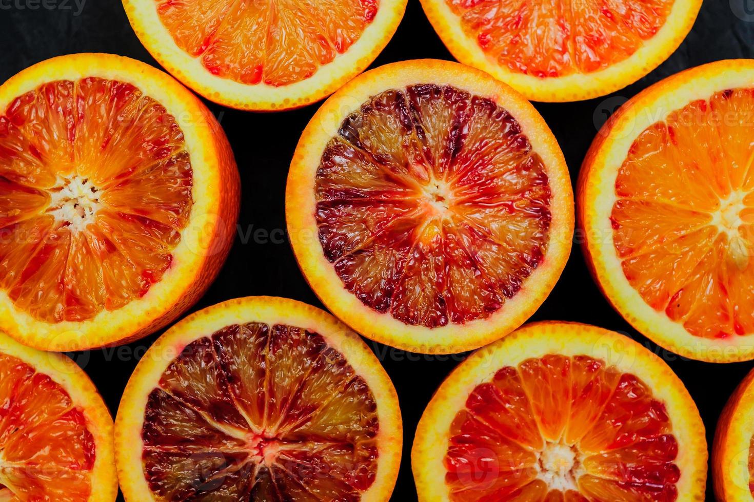 Jucy background made of blood orange slices on black background. photo