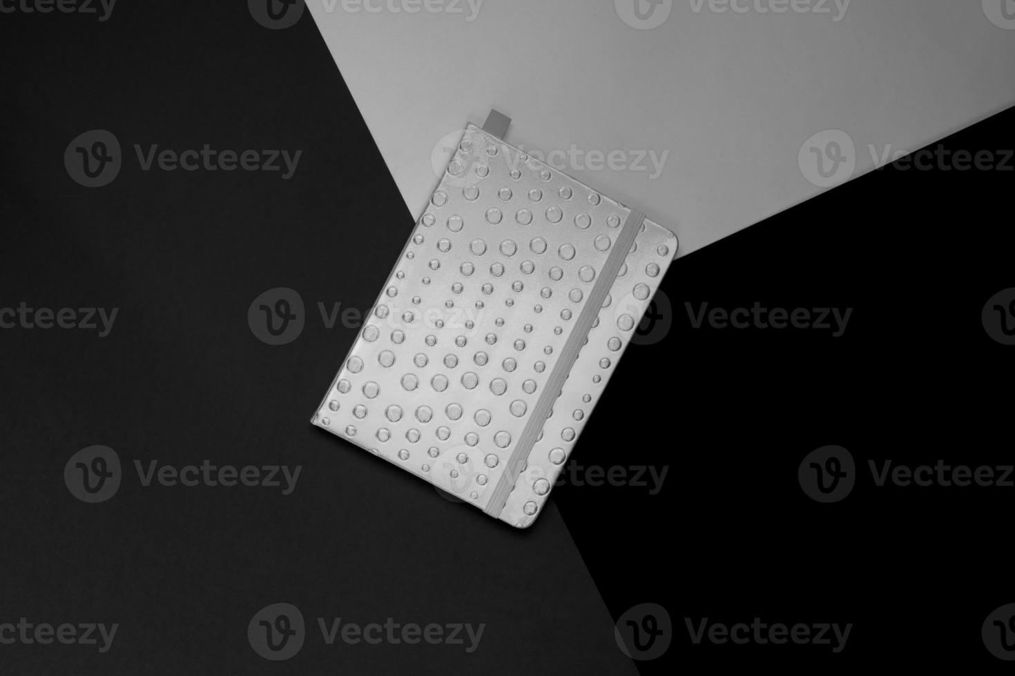 Top view of closed planner on shades of grey background. Black and white. Minimal layout. Creative concept. photo