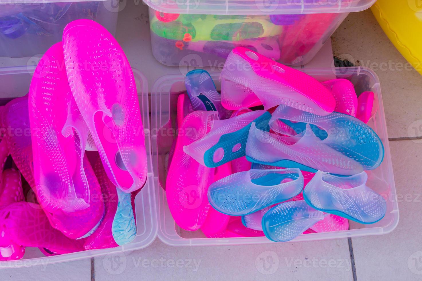 top view of boxes with rubber shoes for swimming in th sea at the local beach market photo