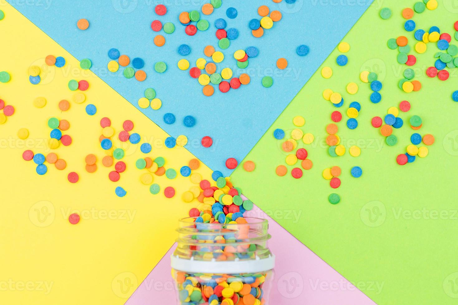 Pop colors. Festive multicolored background with bright sugar sprinkles scattered on paper. photo