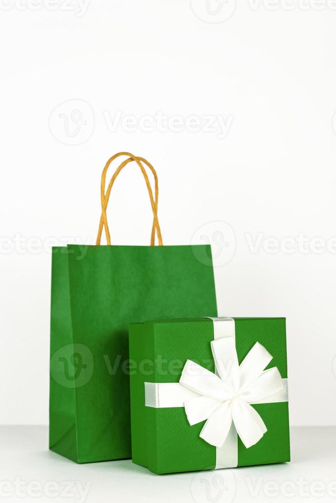 feliz año nuevo 2021 compras navideñas. caja de regalo verde, bolsa de papel artesanal aislada sobre fondo blanco, monocromo. foto