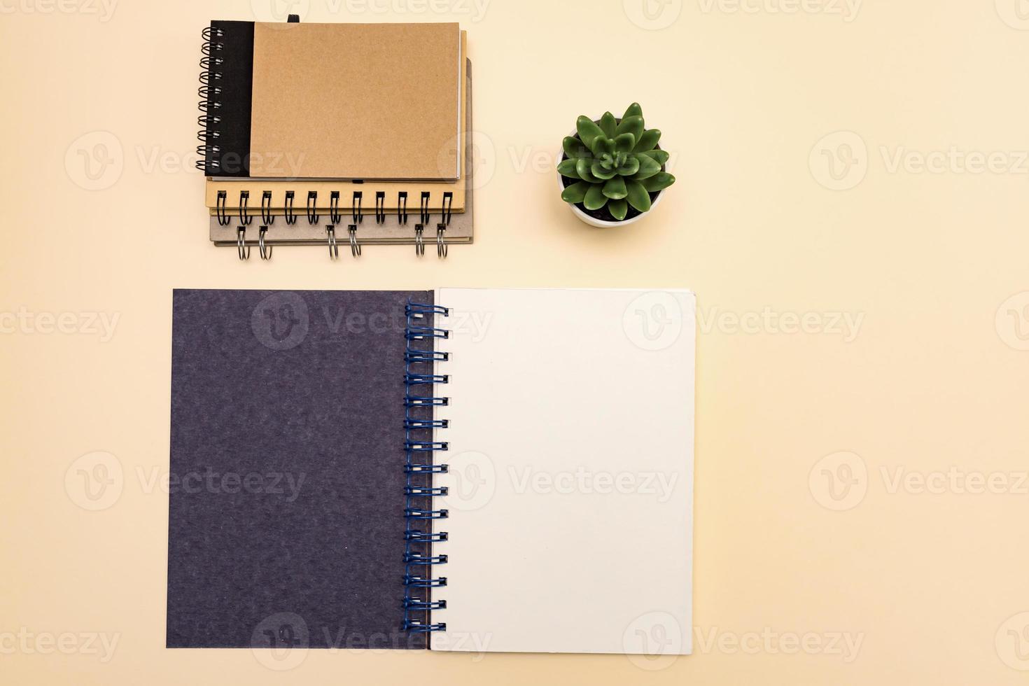 top view eco friendly stack of notebooks, with copy space, made of recycled paper on a pastel background. Mockup for your projects photo