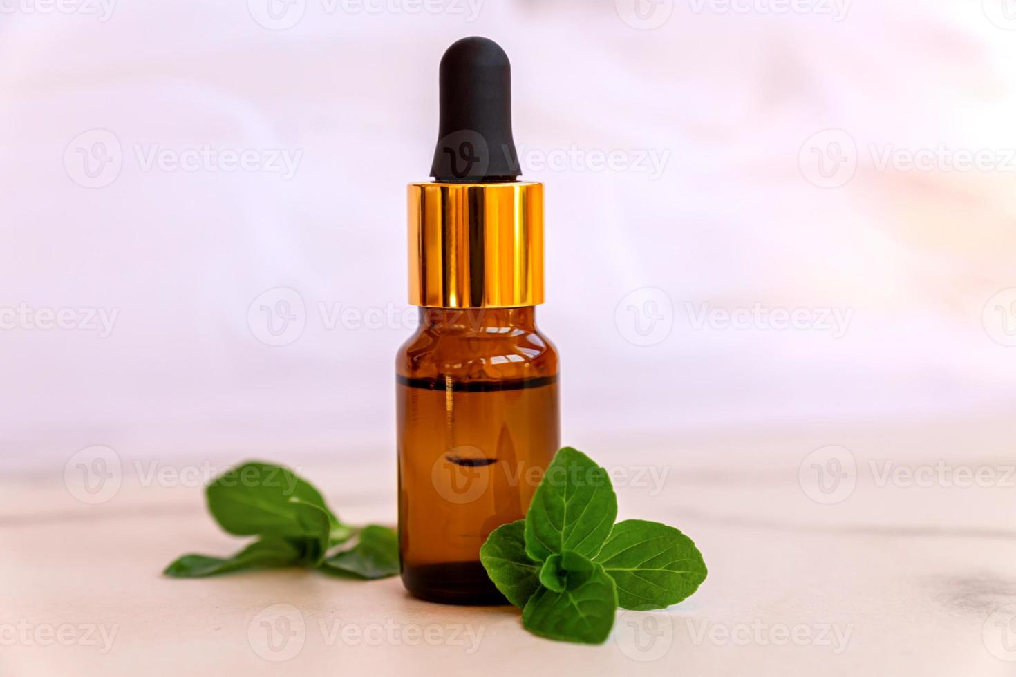 concepto de aromaterapia. aceite perfumado de aroma en botella de vidrio con menta foto