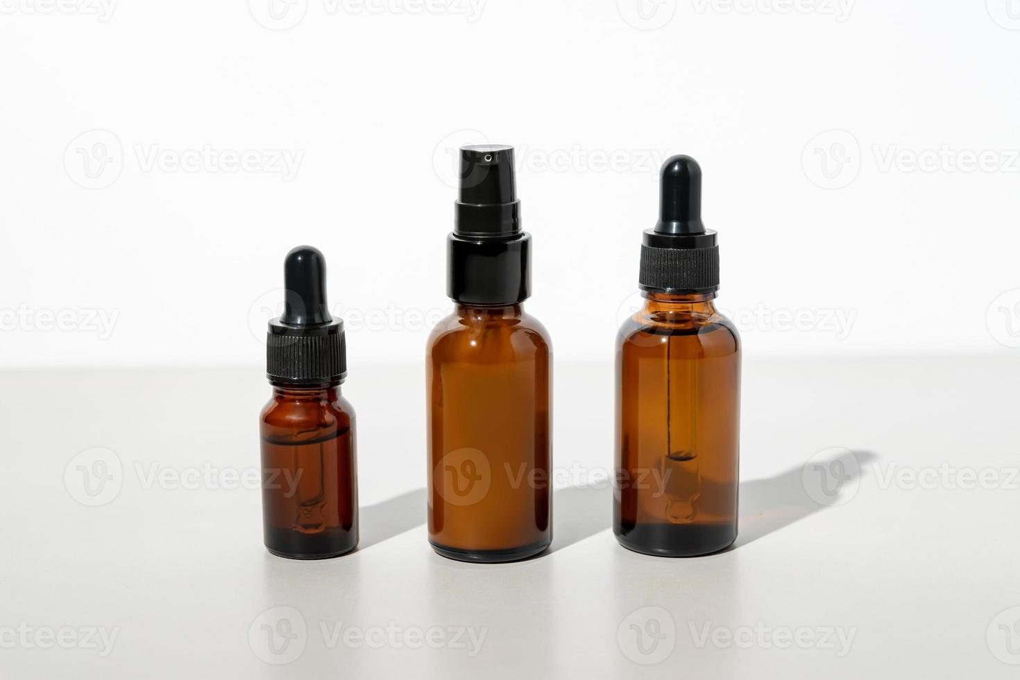 Set of unbranded dark glass bottles for design. essential oil, face serum and cream in mock up package. Minimal style. Trendy concept photo