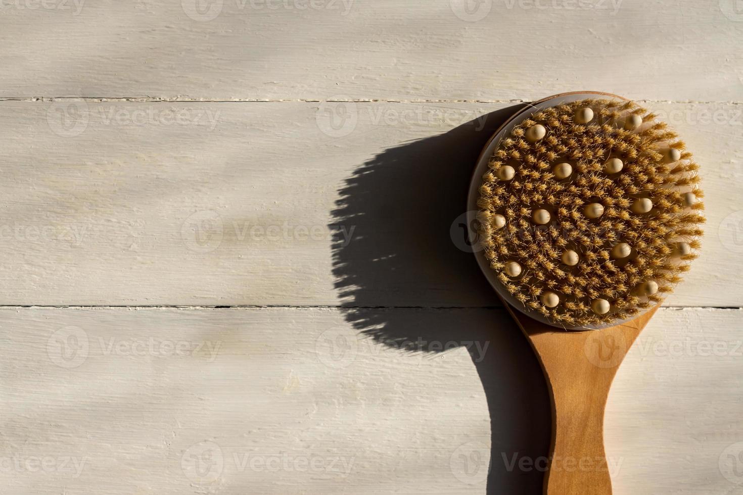 Top view of bath bamboo brush for dry massage om wooden background photo