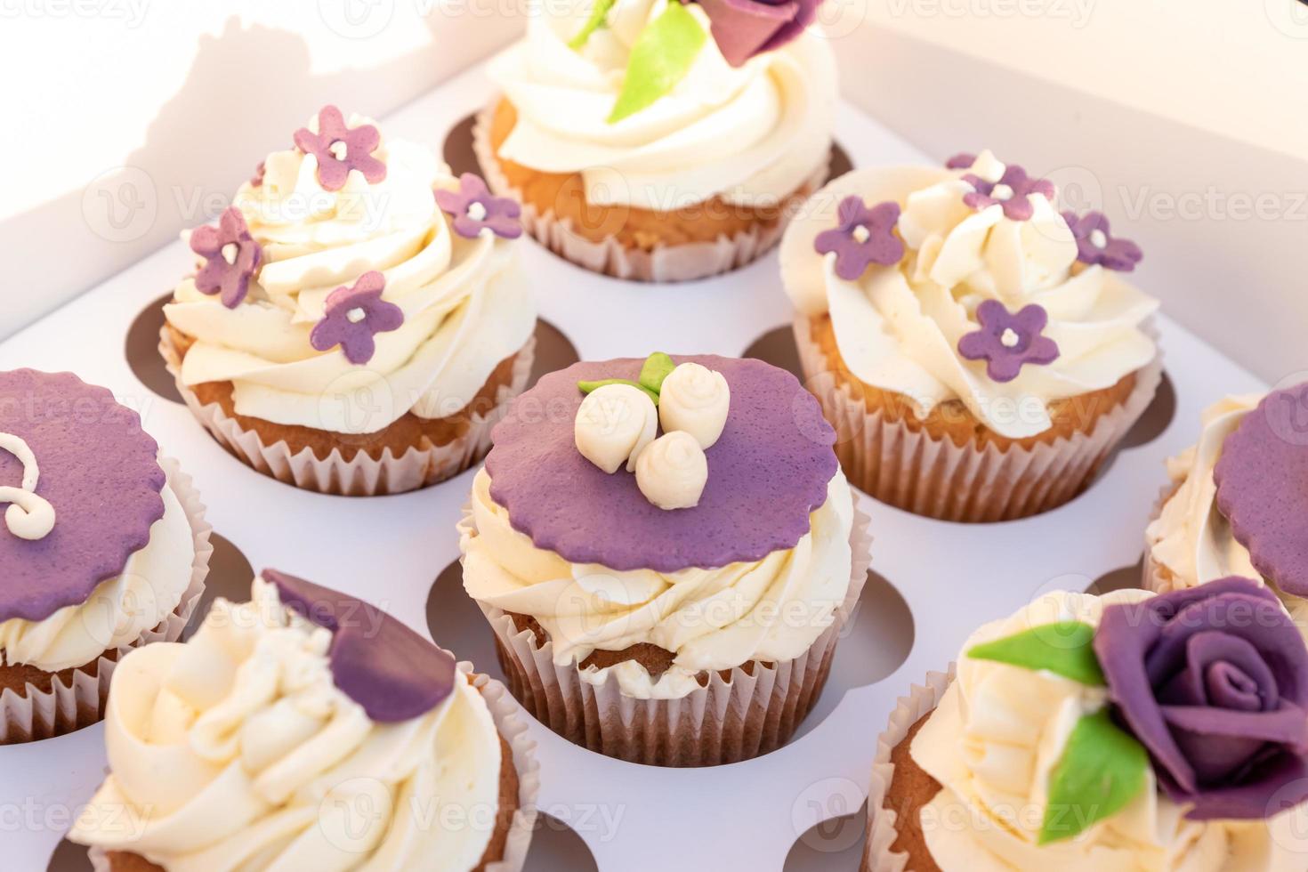 Set of different delicious cupcakes in a paper box for celebration. photo