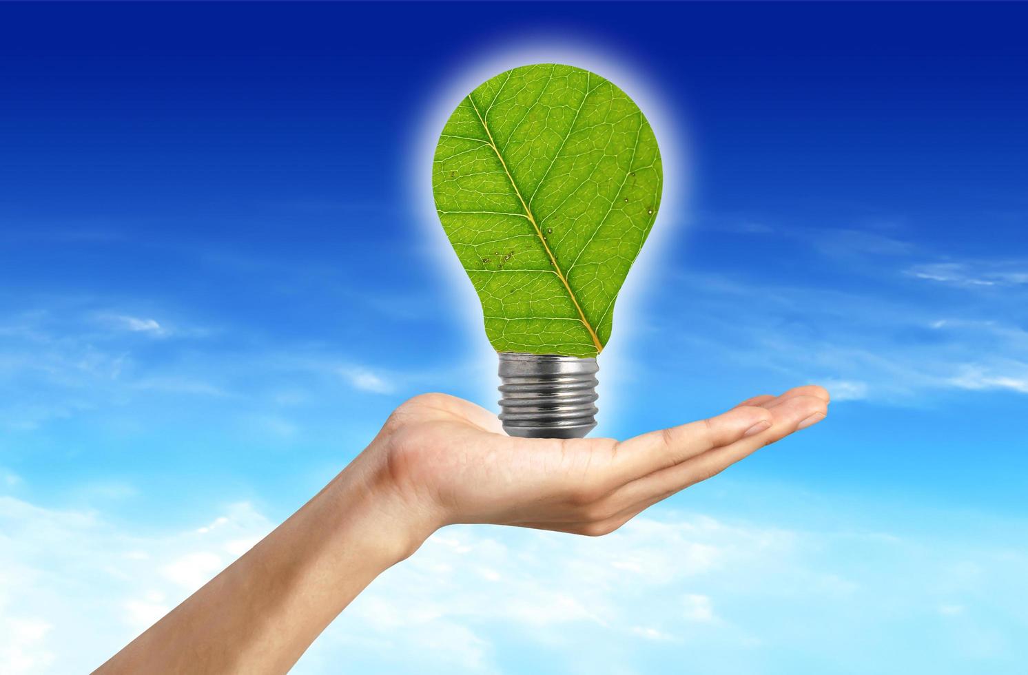 Ecological concept, leaf and lamp mixed together with hand photo