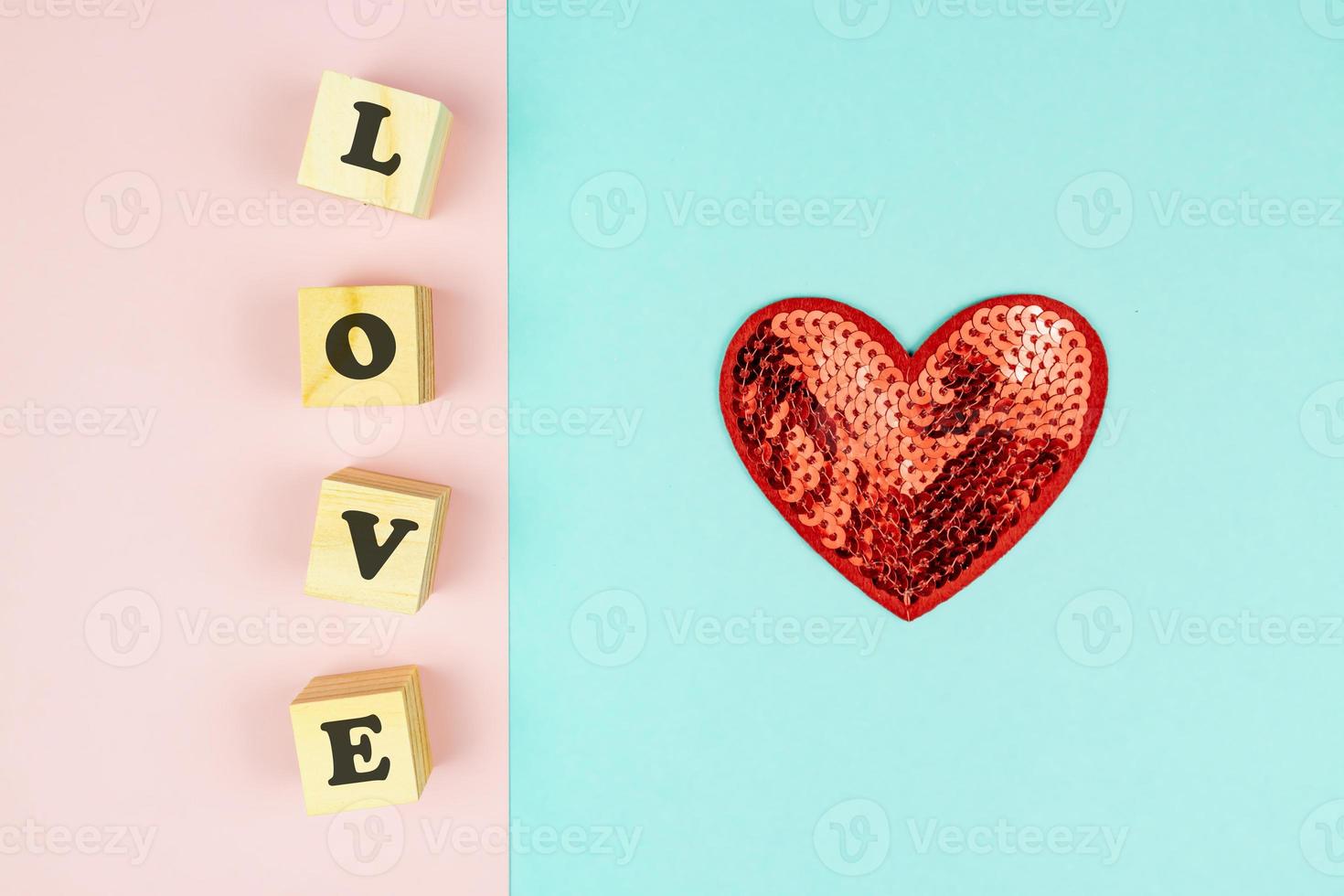 Red hearts and wooden cubes with text LOVE on double blue and pink background. Creative flat lay with copy space. Festive greeting card for St Valentines day. photo