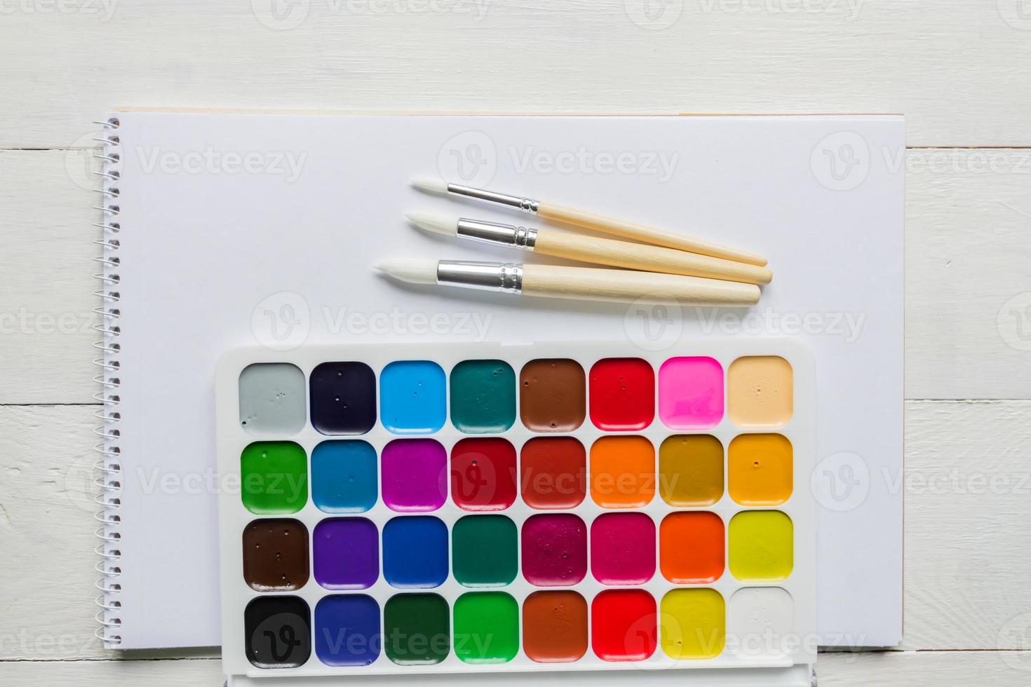 Watercolor paints and brushes, top view. Creative artistic mockup with copyspace. Aquarelle painting photo