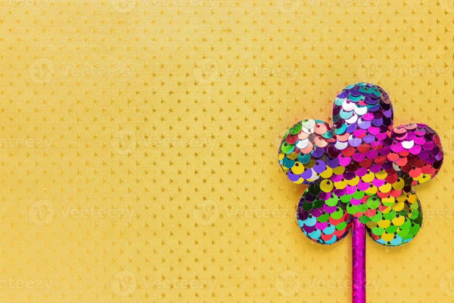 flower made of sequins on sparkling golden background. Minimal flat lay, copy space photo